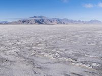 there is a lone motorcycle parked in the desert, with mountains in the background, and no one on the side