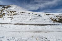 a lone skier is standing on the snow slope in the middle of nowhere, but no one knows what this mountain is