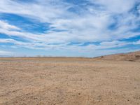 a lone white truck on a barren plain under a partly cloudy sky and clouds of many colors