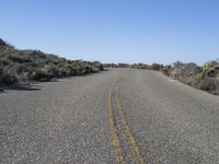 a lonely street with no traffic is shown on this sunny day in the desert,