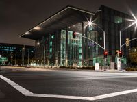 the city streets are lit by traffic lights and on the ground is the tall building