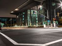 the city streets are lit by traffic lights and on the ground is the tall building