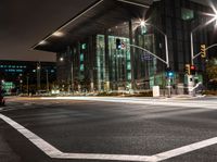 the city streets are lit by traffic lights and on the ground is the tall building