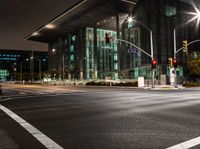 the city streets are lit by traffic lights and on the ground is the tall building