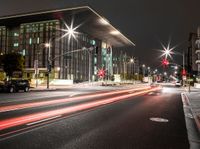 the city streets are lit by traffic lights and on the ground is the tall building