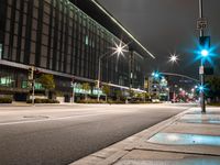 city street lights shine on an empty street in the night time at the intersection of two streets