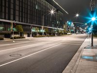 city street lights shine on an empty street in the night time at the intersection of two streets