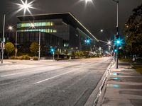 a empty city street at night with lights glowing on the buildings and street curbs