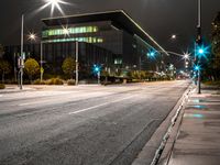 a empty city street at night with lights glowing on the buildings and street curbs