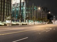 a empty street near large buildings at night time that appears to be driving on the road