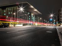 a city street has lights shining brightly on the sides of buildings at night time,