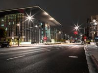 a city street has lights shining brightly on the sides of buildings at night time,