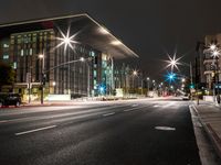 a city street has lights shining brightly on the sides of buildings at night time,