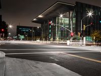 a view at night with lights coming on and a traffic light and road in the distance