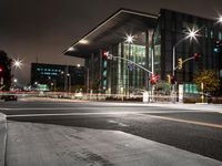 a view at night with lights coming on and a traffic light and road in the distance