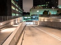 a person on an empty ramp with traffic lights on in a dark city area at night