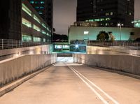 a person on an empty ramp with traffic lights on in a dark city area at night