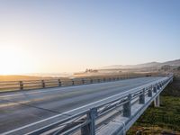 a long bridge spans over the pacific ocean near a sandy beach with a small town in the background