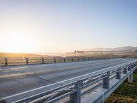 a long bridge spans over the pacific ocean near a sandy beach with a small town in the background