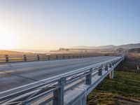 a long bridge spans over the pacific ocean near a sandy beach with a small town in the background