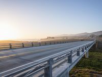 a long bridge spans over the pacific ocean near a sandy beach with a small town in the background