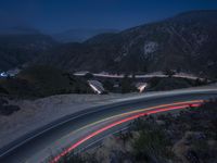 the highway in the mountains is very long exposure at night with long exposures as well