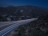 the highway in the mountains is very long exposure at night with long exposures as well