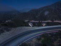 the highway in the mountains is very long exposure at night with long exposures as well