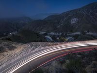 the highway in the mountains is very long exposure at night with long exposures as well