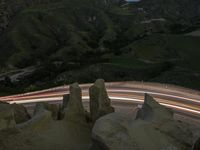 there is a long exposure photo of a curve on a mountain road through some rocks