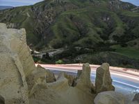 there is a long exposure photo of a curve on a mountain road through some rocks