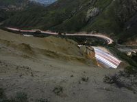 there is a long exposure photo of a curve on a mountain road through some rocks