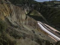 there is a long exposure photo of a curve on a mountain road through some rocks