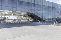 a very long parking garage with many windows and a walkway area underneath it to catch cars and drive by