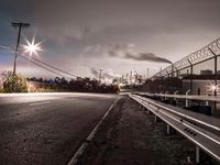 this is an image of a long road with power lines above it and cars driving past