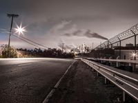 this is an image of a long road with power lines above it and cars driving past