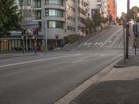 a very long street with a traffic signal above it on the corner of a hill