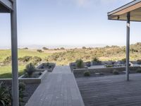 a long walkway leading to a patio with a lawn on the other side and a large open door