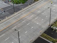 a street next to a car parking lot and palm tree with traffic lines in front