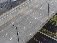 a street next to a car parking lot and palm tree with traffic lines in front