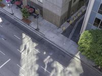 a bird's eye view of the sidewalk on a city street with cars driving down it