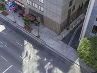 a bird's eye view of the sidewalk on a city street with cars driving down it