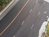 an overhead view of the road between the two roads, from above it shows three lane traffic with white lines that are painted and yellow in a line drawn