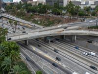 a freeway with several lanes and lots of traffic on it and some cars in the area