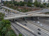 a freeway with several lanes and lots of traffic on it and some cars in the area