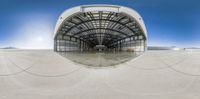 an airplane is flying near a hangar with people around it and a clear blue sky