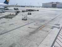 an airplane is parked on the tarmac at an airport with luggage carts and other equipment