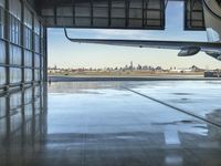 an airplane parked in front of the windows of the hangar with a view of new york