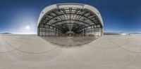 an airplane is flying near a hangar with people around it and a clear blue sky