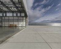 a plane is parked inside a large hangar at the airport in daylight, with a lot of glass on the outside